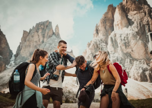 Group of hikers helping each other across rocky mountain terrain